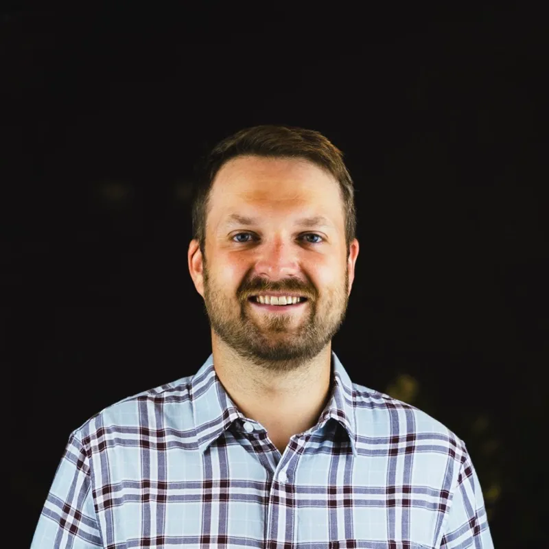 Kaspars, smiling, in a checked shirt